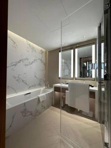 La salle de bains est pourvue d'une douche, d'une baignoire et d'un lavabo. dans l'établissement Dreamy 2BR Haven, Downtown Bliss, à Dubaï