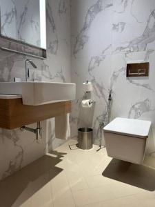 La salle de bains est pourvue d'un lavabo et de toilettes. dans l'établissement Dreamy 2BR Haven, Downtown Bliss, à Dubaï