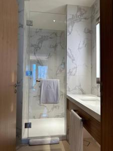a bathroom with a glass shower and a sink at Dreamy 2BR Haven, Downtown Bliss in Dubai