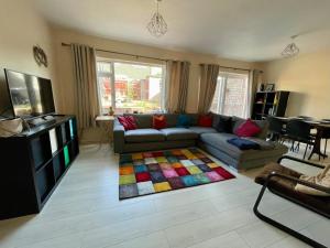 a living room with a couch and a colorful rug at CROYDON Spacious 3 Bedroom Family House in Addington