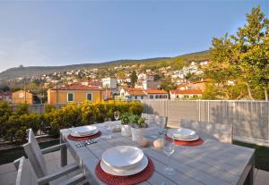 une table blanche avec des assiettes et des verres sur un balcon dans l'établissement Casa Vacanze Barcola, à Trieste