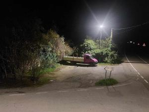 un camión rosa estacionado en un estacionamiento por la noche en Hotel Moto-Rural "VEGALION", en Las Salas