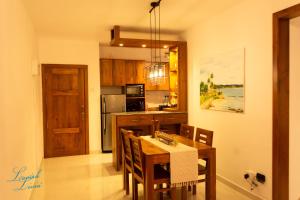 a kitchen with a table and chairs and a refrigerator at Lavish Livin’ in Galle