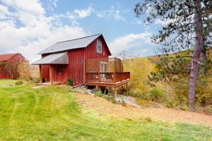 a red barn with a deck on a field at Running Fox Farm in Baraboo