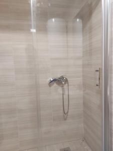 um chuveiro com uma porta de vidro na casa de banho em Relax in Apartment Stela em Skopje