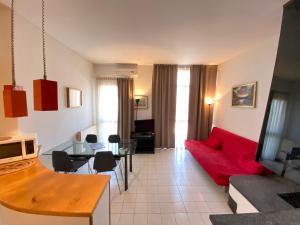 ein Wohnzimmer mit einem roten Sofa und einem Tisch in der Unterkunft Appartamenti Leonardo in Brescia