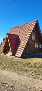 ein großes Holzgebäude mit rotem Dach in der Unterkunft Koliba Kika in Bajina Bašta