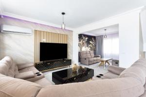 ein Wohnzimmer mit 2 Sofas und einem TV in der Unterkunft Villa Exotica in Adeje