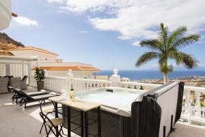 a balcony with a pool and a table and chairs at Villa Exotica in Adeje