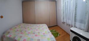 ein kleines Schlafzimmer mit einem Bett und einer Kommode in der Unterkunft Apartman Emilija in Bačka Palanka