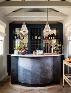 Journey East Hampton في إيست هامبتون: يوجد بار في مطبخ مع أضواء قلادة