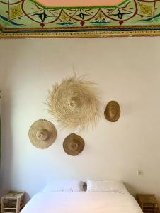 Ściana z trzema kapeluszami wiszącymi na ścianie w obiekcie Kasbari House w mieście Taghazout