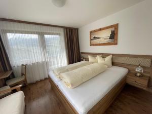 een slaapkamer met een groot wit bed en een raam bij Gästeheim Lederle in Jerzens