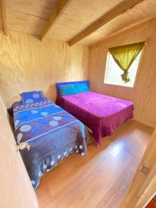 a small room with two beds and a window at Casa de campo in Lago Ranco