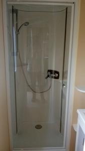 a shower with a glass door in a bathroom at MOBILHOME CHEZ SYLVIE AU CAMPING DE PUJOL in Argelès-sur-Mer