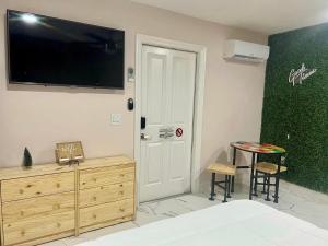 a room with a table and a tv on the wall at Busch Gardens Bliss Suite-2 in Tampa