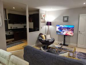 Apartment In Birmingham New Street في برمنغهام: غرفة معيشة مع أريكة وتلفزيون بشاشة مسطحة