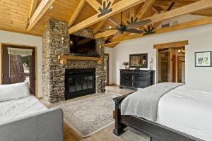 a bedroom with a stone fireplace and a bed at Gorgeous North Fork Cabin Near Bass Lake! in North Fork