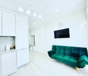 a living room with a green couch and a tv at Rent Apartament 2 camere Chirie in Chişinău