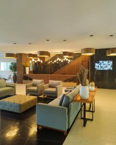 RN Studio Premium في ماسيو: غرفة معيشة مع أريكة وكراسي وطاولة