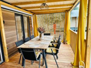 a wooden table and chairs on a deck at Sandra Holiday Homes in Biograd na Moru