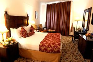 a hotel room with a bed and a desk at Hotel Hillview Islamabad in Islamabad