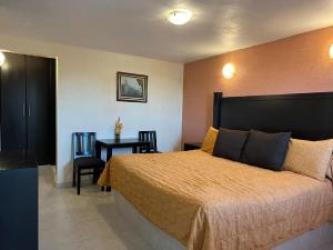 1 dormitorio con 1 cama y 1 mesa con sillas en Hotel Posada Real, en Mineral del Monte