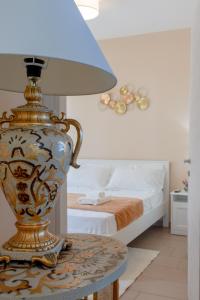 a vase sitting on a table next to a bed at L'Affaccio Rooms - Lungomare Gallipoli in Gallipoli