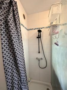 La salle de bains est pourvue d'une douche avec rideau de douche. dans l'établissement Chambres dans Grand Appartement - Centre-ville, à Montpellier