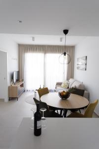 ein Wohnzimmer mit einem Tisch mit einer Flasche Wein in der Unterkunft La Casa Costera Càlida in San Pedro del Pinatar