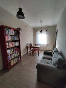 sala de estar con sofá y estantería con libros en Casina Lubric, en Diano dʼAlba