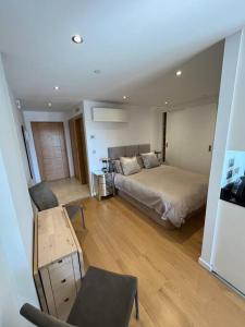 1 dormitorio con 1 cama, 1 mesa y 1 silla en Gibraltar Luxury with Rooftop Pools & Views en Gibraltar