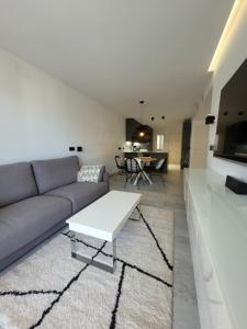 a living room with a couch and a table at El Olive - Calanova Grand golf in Mijas