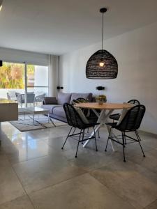 sala de estar con mesa y sofá en El Olive - Calanova Grand golf en Mijas