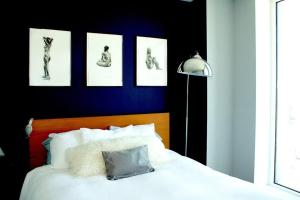 a bedroom with a white bed with pictures on the wall at LES is MORE stunning views! in New York