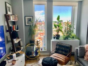 una sala de estar con una ventana con plantas y una silla en LES is MORE stunning views! en Nueva York