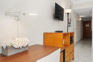 a living room with a table and a tv on a wall at Biarritz Studio - Beautiful Ocean View Studio in San Juan