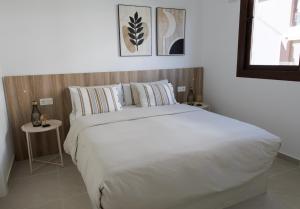 ein Schlafzimmer mit einem großen weißen Bett und einem Tisch in der Unterkunft La Casa Costera Càlida in San Pedro del Pinatar