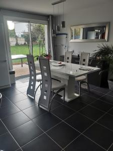 een witte tafel en stoelen in de woonkamer bij La maison de Marie 