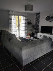 een woonkamer met een bank en een tv bij La maison de Marie 
