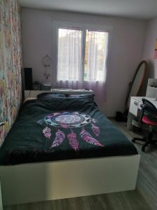 een slaapkamer met een groot bed en een zwart dekbed bij La maison de Marie 