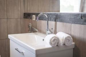 a bathroom sink with towels on top of it at 2022 Central Apartment Maribor (Garden + Parking) in Maribor +8 photos