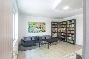 a living room with a couch and book shelves at 2022 Central Apartment Maribor (Garden + Parking) in Maribor