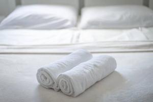 two rolled towels sitting on top of a bed at 2022 Central Apartment Maribor (Garden + Parking) in Maribor