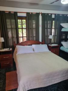 a bedroom with a large white bed with windows at Espacio Verde in Salta