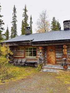 a log cabin with benches in front of it at Chalet Luoston Lustitupa 3 in Luosto