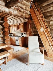 Una silla blanca en una cocina en una cabaña de madera en Chalet Luoston Lustitupa 3, en Luosto