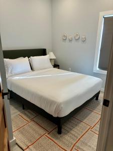 una camera da letto con un grande letto con lenzuola bianche di Collect3 2BR 1BA Close to Train and NYC a Newark