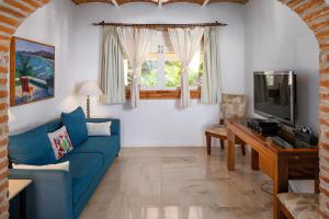 a living room with a blue couch and a tv at Tia Adriana in Sayulita