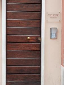a wooden door with a sign on a house at COSTHOUSE in Brescia
